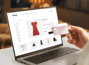 Shopping online with credit card concept. Modern e-commerce web page with woman clothes on laptop display